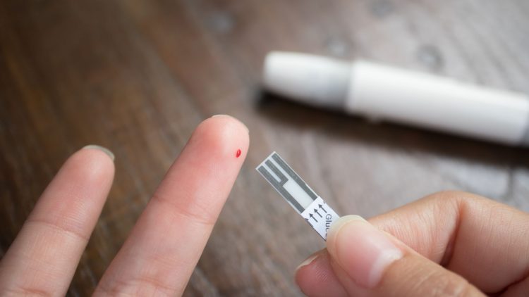 Blutentnahme am Finger mit Plastikröhrchen