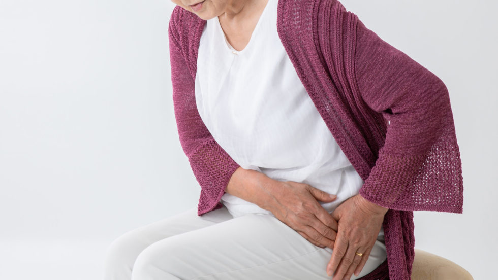 Frau hält sich die Hüfte wegen Arthroseschmerzen